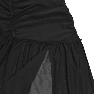 Détail de la robe noire avec design froncé, empiècements en maille et fente latérale
