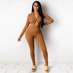 Detail van caramel geribde gebreide tweedelige set met korte rits top en nauwsluitende broek