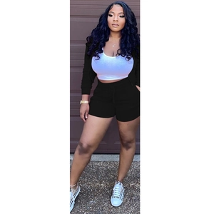 Outdoor shot of a women's three-piece set featuring a black hoodie and drawstring shorts