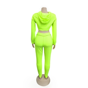 Vista posteriore della tuta sportiva verde neon due pezzi con felpa crop e pantaloni