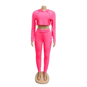 Dettaglio della tuta sportiva rosa neon due pezzi con felpa corta e pantaloni joggers slim