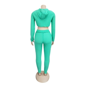 Dettaglio del set sportivo con felpa corta e pantaloni joggers in verde neon