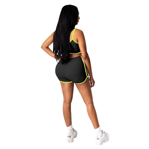 Vue arrière de l'ensemble de yoga noir et jaune fluo avec haut court et short côtelé