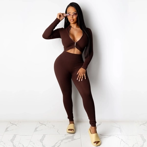Detail van chocoladebruine geribbelde gebreide tweedelige set met korte top en legging