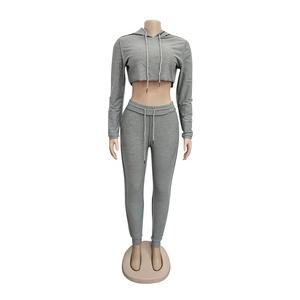 Dettaglio della felpa corta con cappuccio e dei pantaloni del completo sportivo grigio