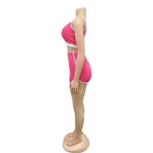 Vue latérale de l'ensemble de yoga côtelé rose avec finitions blanches sportives