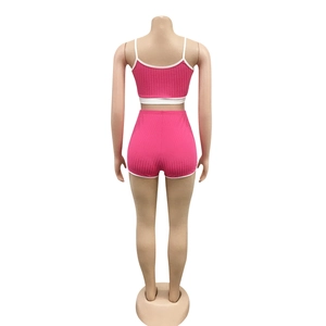 Vue arrière de l'ensemble de yoga côtelé rose avec détails blancs sur le haut et le short