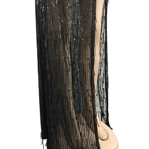 Detail of black sequin tassel dress showing vertical sequin patterns and long fringe trim