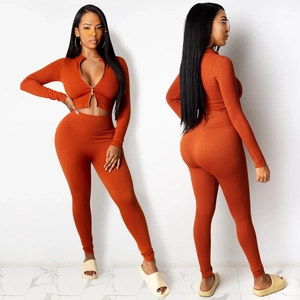 Gebreide tweedelige set in verbrand oranje met crop-top met rits en hoge taille broek