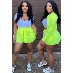 Close-up of three-piece set featuring neon green hoodie, white crop top and drawstring shorts
