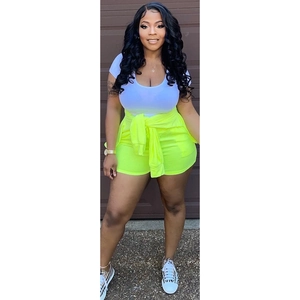 Detail of three-piece set featuring white t-shirt, neon shorts, and matching tied sweatshirt