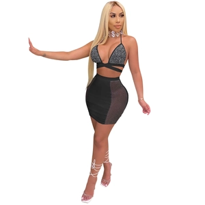 Detail of black two-piece clubwear featuring sparkling rhinestone bra and mesh skirt