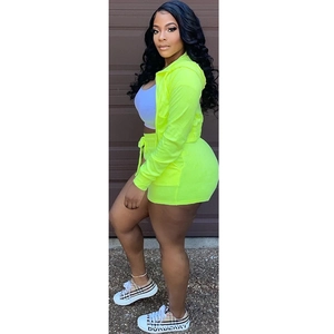 Detail of neon yellow women's track set with zip-up hoodie and drawstring shorts