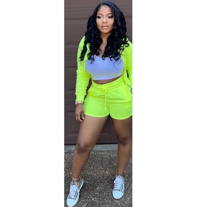 Detail of neon green 3-piece set with zip jacket, crop top and drawstring shorts