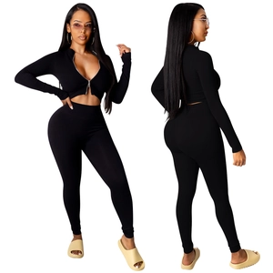 Detail van een geribbelde zwarte tweedelige set met crop top met rits en smalle leggings