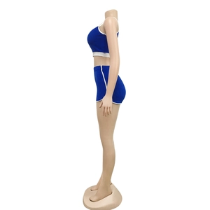 Détail de l'ensemble de yoga bleu avec liseré blanc, incluant débardeur et short taille haute