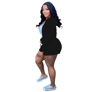 Side view of woman in black hooded jacket and drawstring shorts casual sportswear set