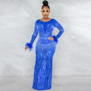 Dettaglio dell'abito da sera blu in mesh con strass e polsini in piuma sulle maniche