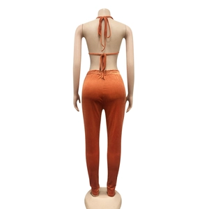 Détail d'un ensemble deux pièces en velours orange caramel avec haut licou et pantalon