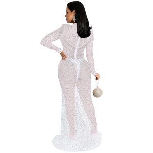 Détails de la robe en maille blanche ornée de cristaux et de motifs volutes élégants