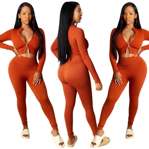Detail van gebreide tweedelige set met korte rits-top en een legging met een hoge taille