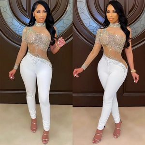 White one-shoulder jumpsuit with sheer mesh sleeve and shimmering rhinestone accents