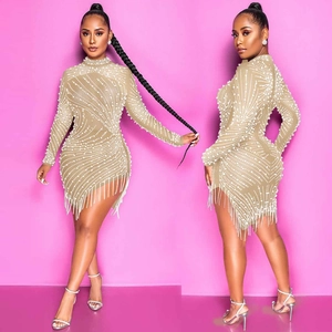 Detail of champagne mini dress featuring intricate pearl beading and elegant fringe hemline