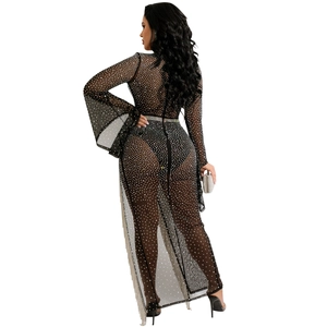 Dettaglio dell'abito in mesh nero con strass argentati e orlo con lunghe nappe