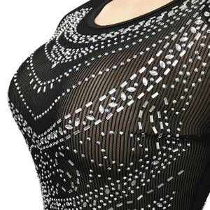 Gros plan d'une robe noire en résille transparente avec des strass argentés brillants
