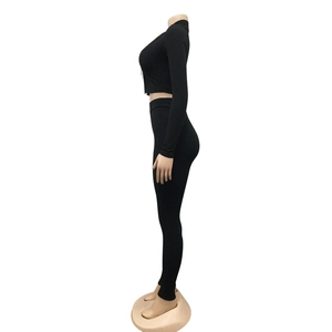 Detailweergave van zwart geribbelde gebreide tweedelige set met crop top en legging