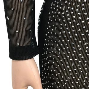 Détail du tissu en maille noire avec strass brillants et textures à rayures verticales