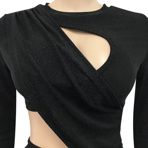 Dettaglio dell'abito nero a maniche lunghe con tessuto glitterato e cut-out asimmetrico