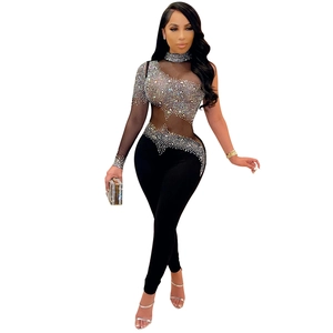 Detail showing sheer mesh fabric with silver rhinestones on an asymmetrical jumpsuit