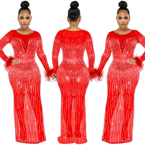 Dettaglio abito da sera rosso in mesh con strass scintillanti ed eleganti polsini in piume