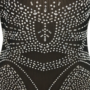 Détail de strass argentés scintillants sur le tissu en mesh côtelé noir de la robe