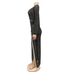 Dettaglio dell'abito in mesh nero con strass argentati e spacco alto con frange