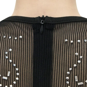 Détail d'une fermeture éclair invisible sur robe en mesh noir avec strass argentés