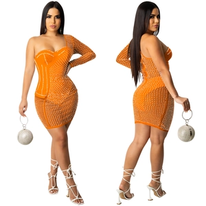 Détail de la mini-robe en résille orange avec strass perlés et texture de manche asymétrique