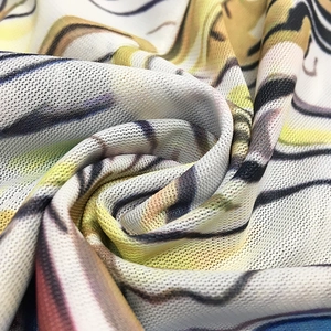 Détail macro du tissu en maille respirant avec des motifs abstraits jaunes et violets