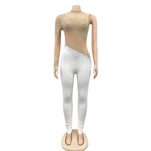 Macro detail of asymmetric sheer mesh jumpsuit with sparkling rhinestones and white pants