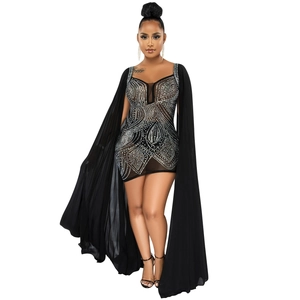 Detail of sheer black mesh dress with rhinestone patterns and long cape sleeves