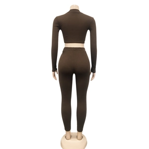 Detail van de donkerbruine gebreide tweedelige set met crop top met lange mouwen en legging