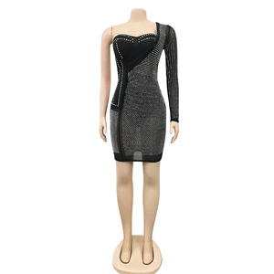 Détail de la robe en maille à strass avec manche longue asymétrique et coupe moulante sexy