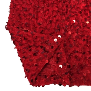Detailed macro view of vibrant red sequin fabric texture with dense round metallic paillettes