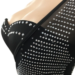 Détail d'une robe moulante noire en mesh avec des ornements en strass argentés brillants