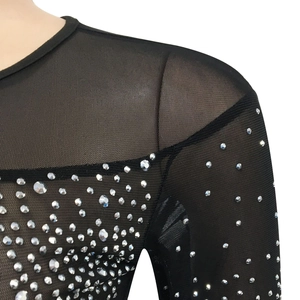 Dettaglio di un abito in rete trasparente con strass argentati sulla scollatura rotonda