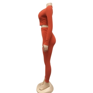 Detail van de oranje geribbelde gebreide stof op de dames slim fit top en broek set