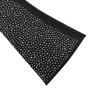 Dettaglio dell'abito in rete nera con strass argentati luccicanti e texture riflettente