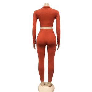 Achteraanzicht van oranje geribbelde gebreide tweedelige set met crop top en legging