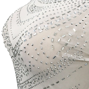 Gros plan d'une robe en mesh blanc avec des strass complexes et des détails transparents